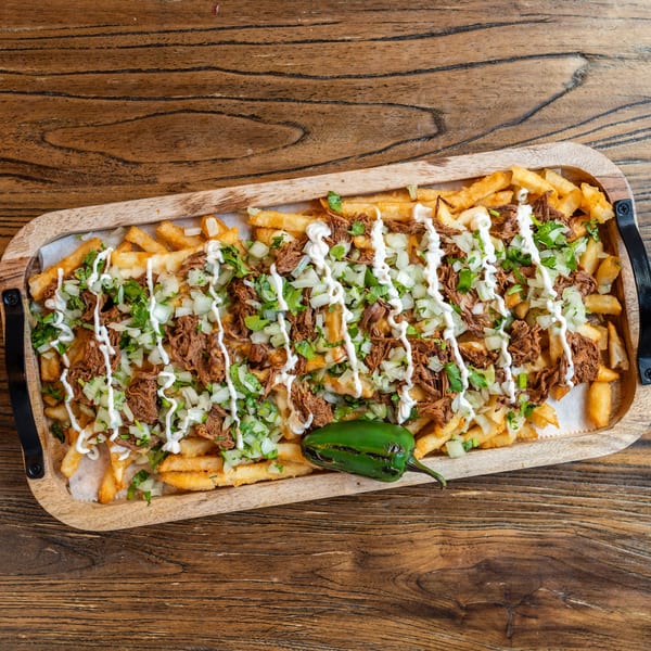 Mexican Mariachi Grill's loaded fries with shredded meat, onions, cilantro, crema, and a jalapeño.
